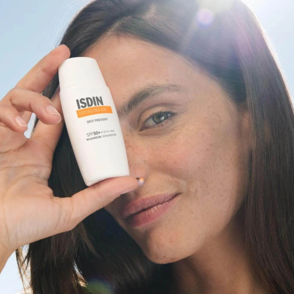Femme tenant le flacon ISDIN FotoUltra 100 Spot Prevent SPF 50+