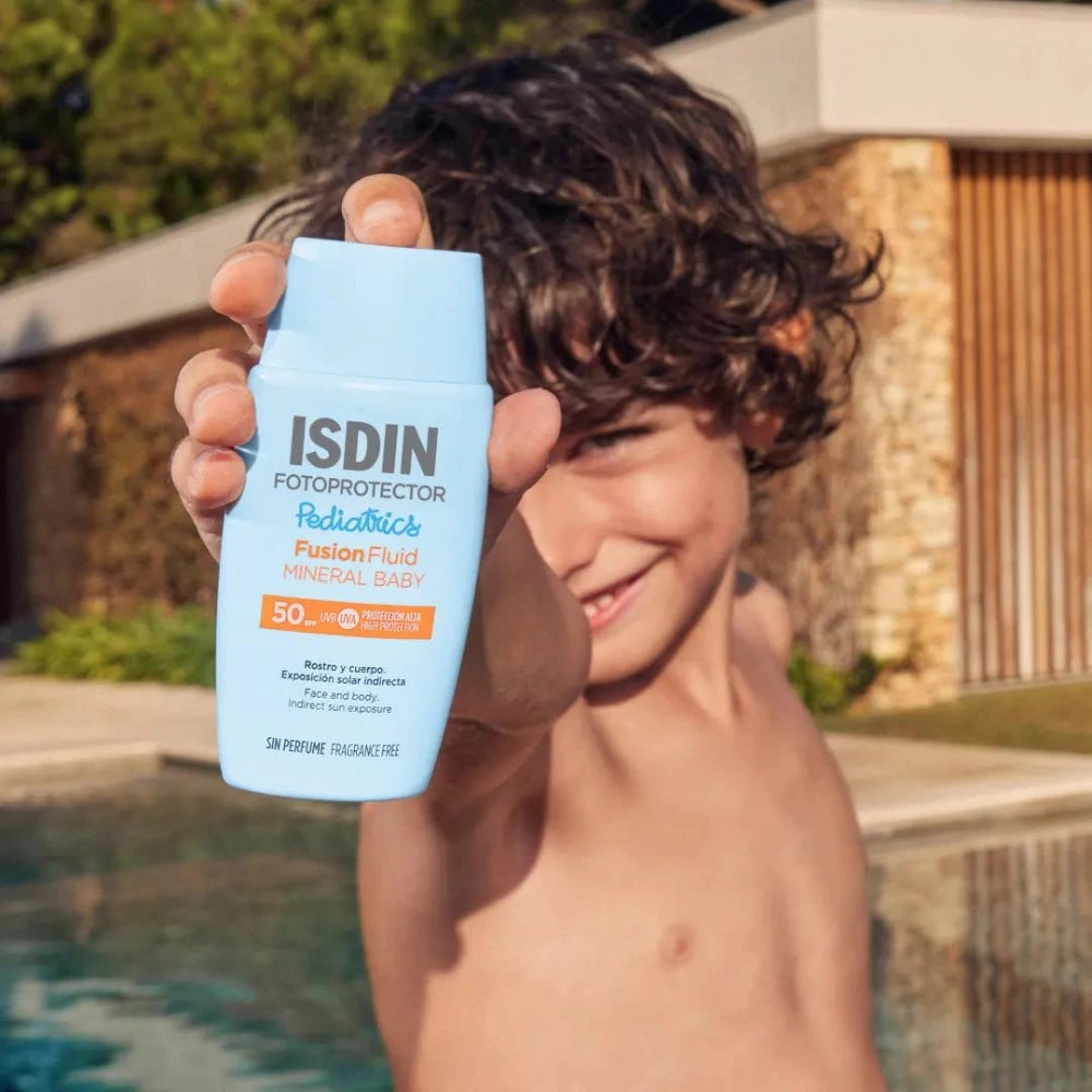 Enfant montrant le flacon ISDIN Pediatrics Fusion Fluid Mineral Baby SPF 50